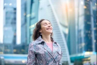 Een vrouw die zich voor een stadsgebouw bevindt.