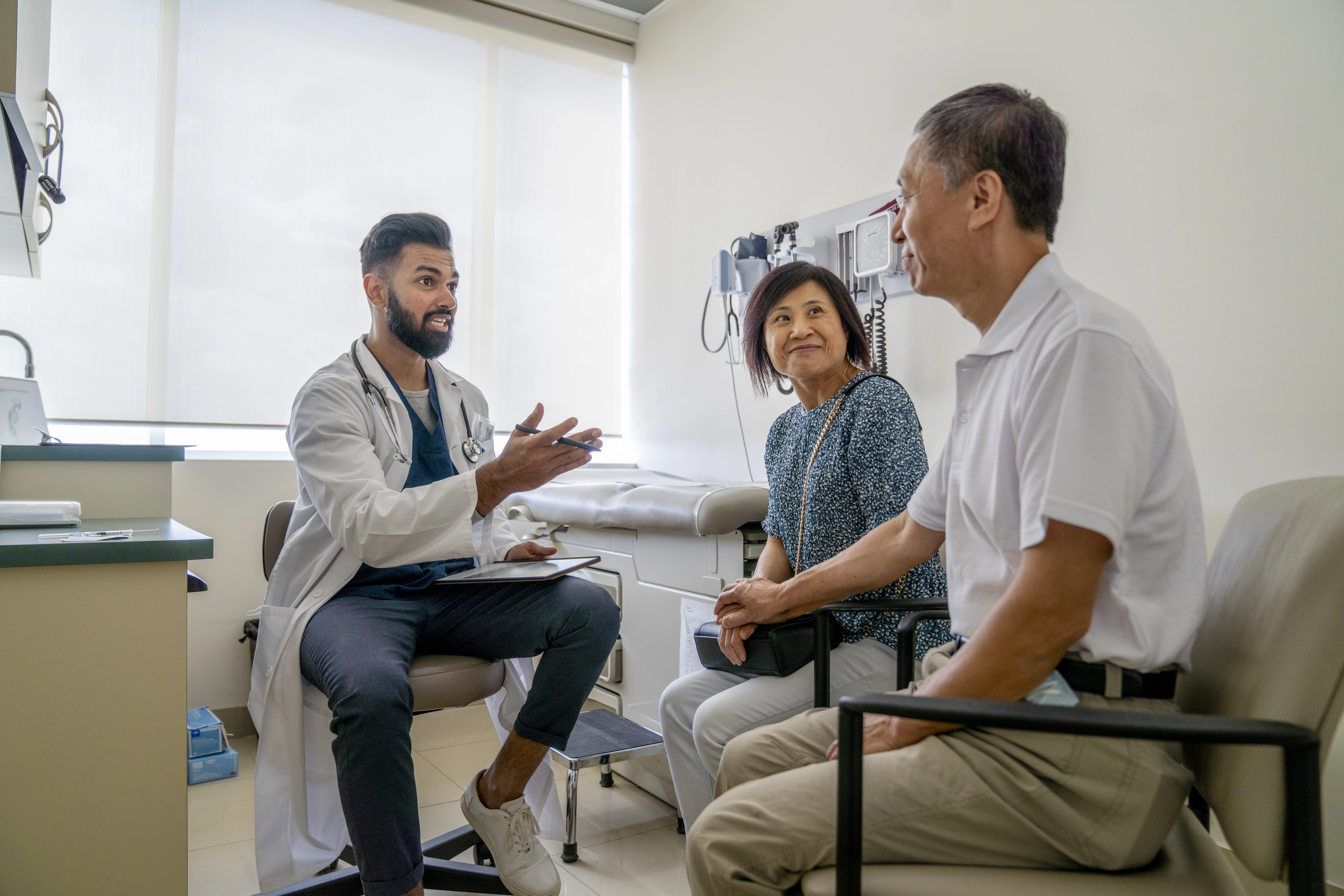 Profesional de la salud hablando con dos personas