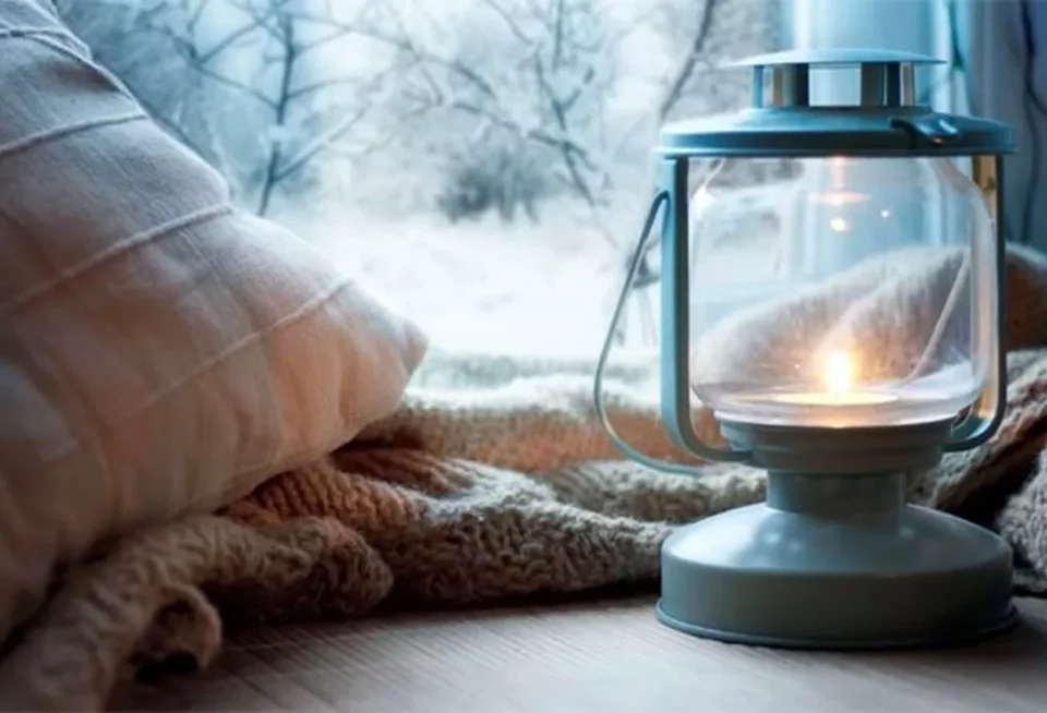 mačka ležiaca na deke vedľa lampy