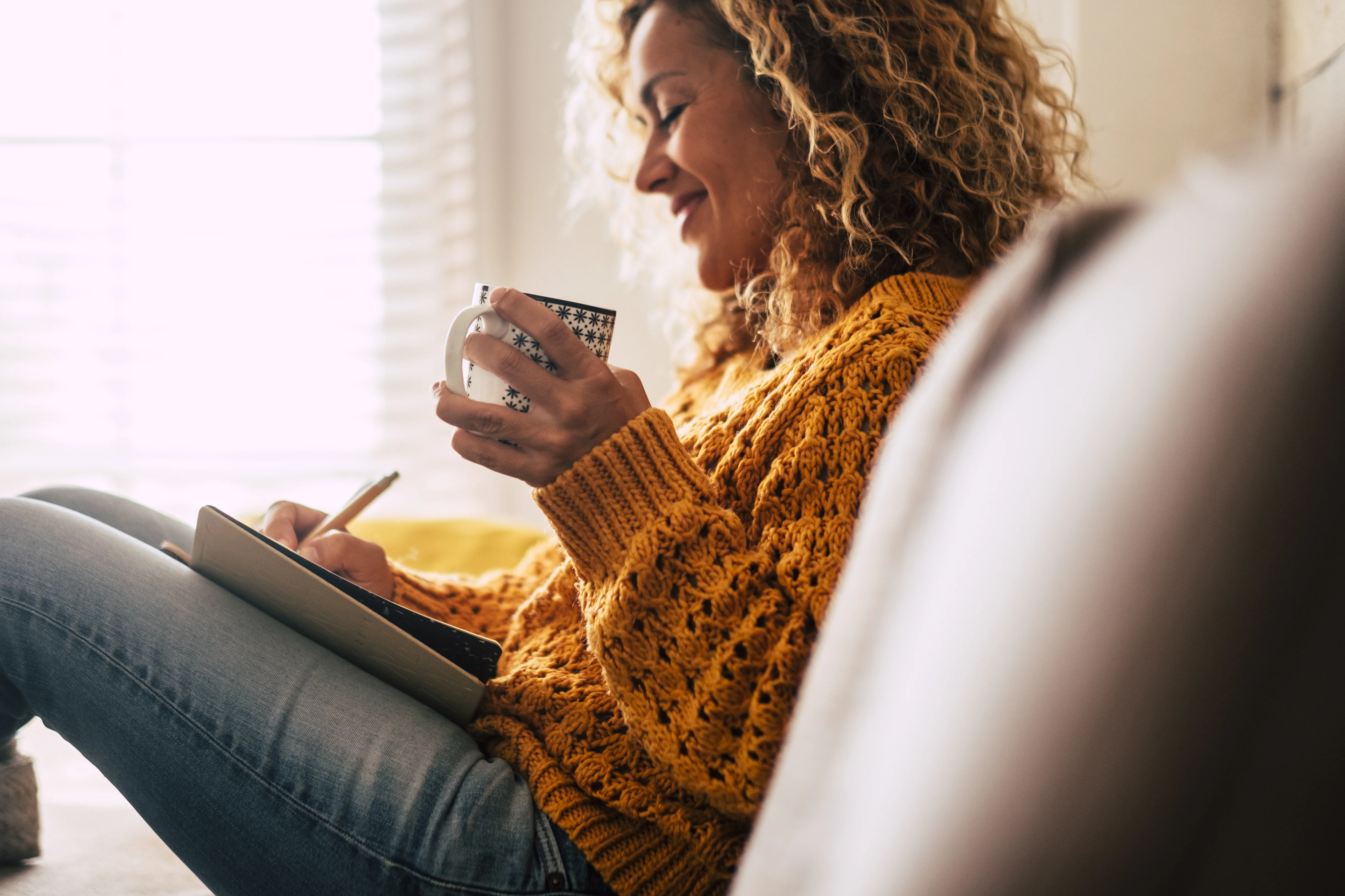 a woman sitting on a couch and using a phone