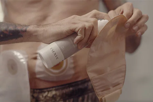 En man som sprayar en produkt på en stomipåse